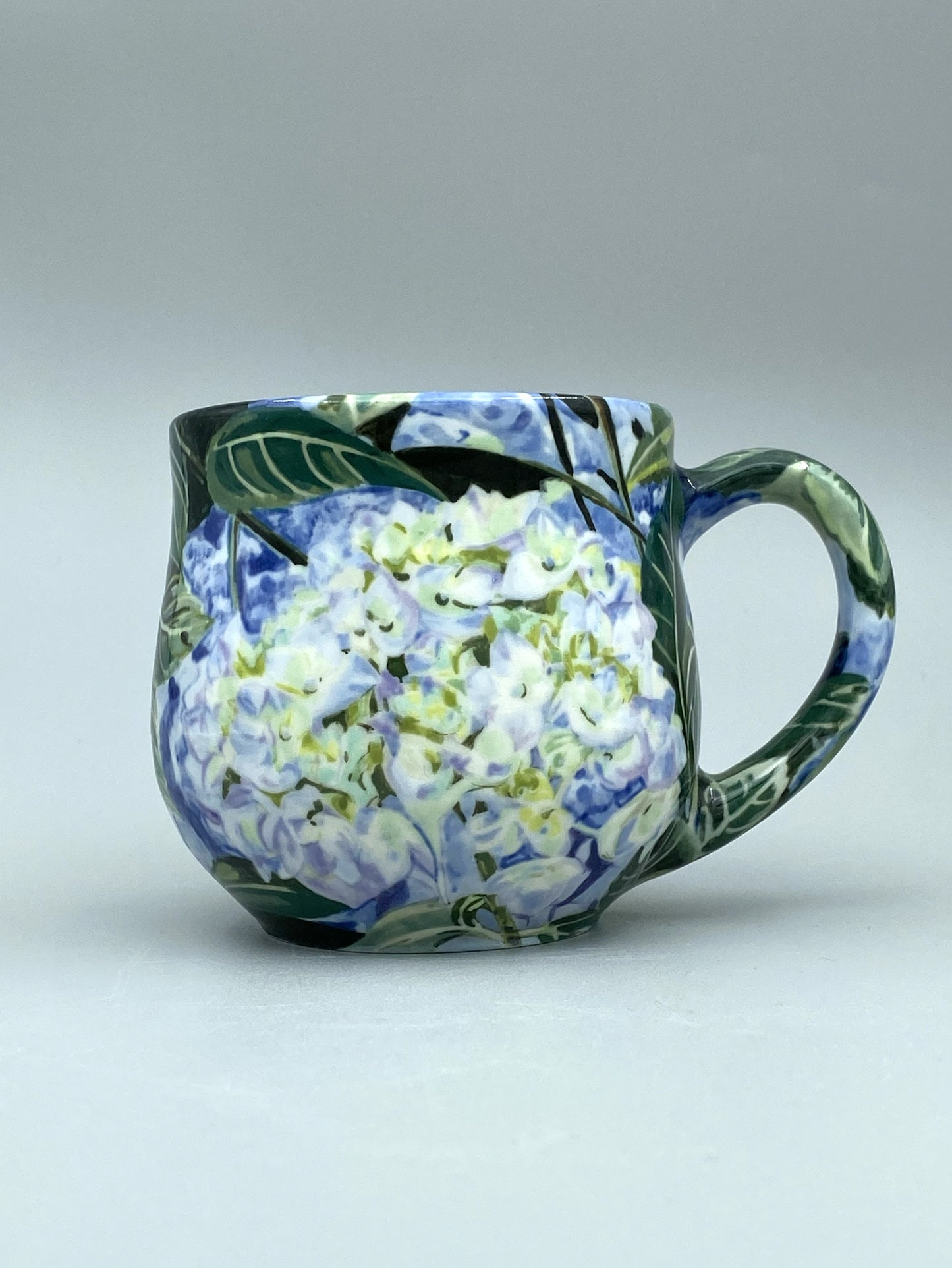 Ceramic mug with floral design on a plain background