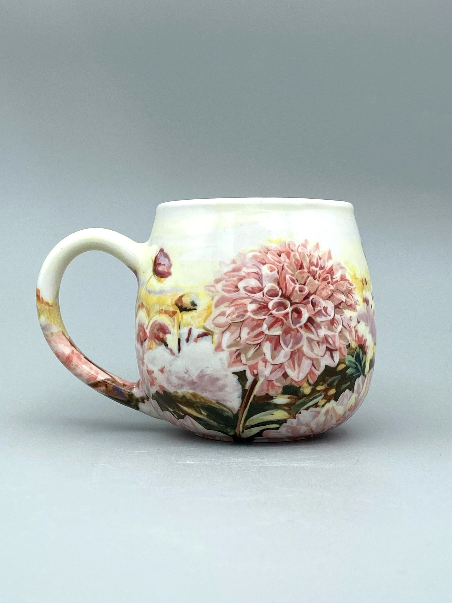 Ceramic mug with floral design on a gray background